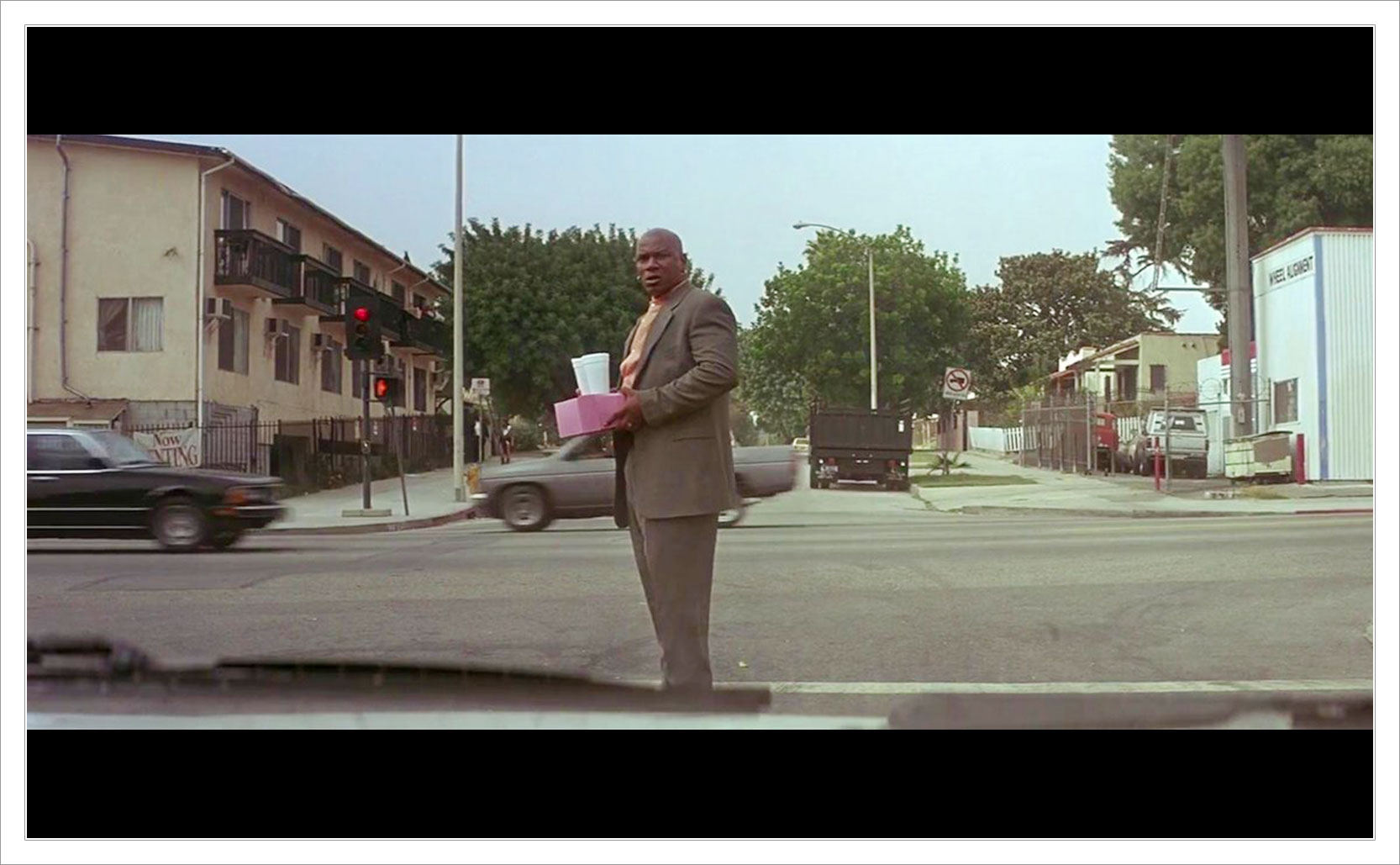 the character of Marsellus Wallace crossing the street in Pulp Fiction carrying a box of doughnuts